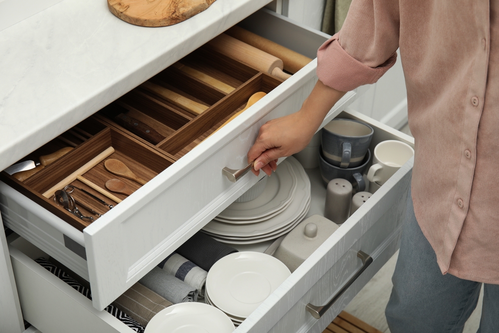 Woman,Opening,Drawers,Of,Kitchen,Cabinet,With,Different,Dishware,And Frameless Cabinets